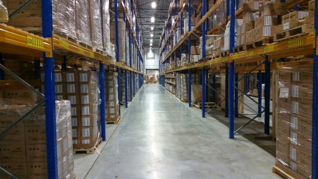 Home Interior view of a large warehouse aisle lined with stacks of organized cardboard boxes.